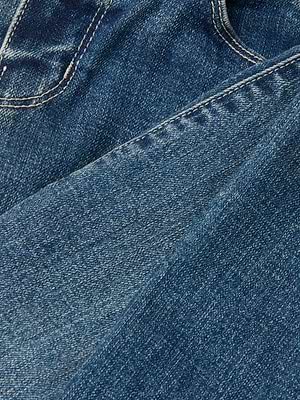 Close-up of blue Sada Cropped Slim-Leg Jean denim shows a seam and pocket. The textured stitching highlights the quality stretch fabric, combining comfort and style.