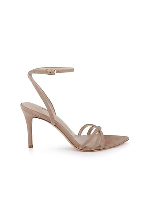 The Dua Suede Sandal is a tan strappy suede sandal with a pointed toe, thin ankle strap and small buckle, two slim front straps, and a stiletto heel, shown against a white background.